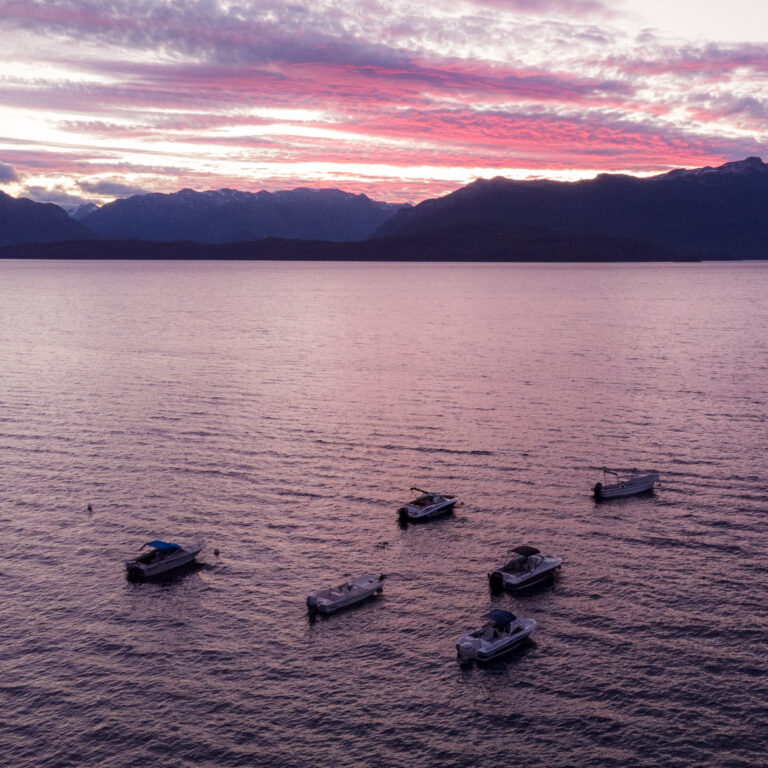 Atardecer sobre el lago Nahuel Huapi con embarcaciones en Puerto Elma